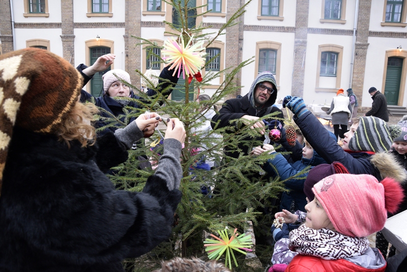 Muzeja pagalmā mazie baušķenieki izrotā eglītes, mielojas ar pankūkām un rotaļājas