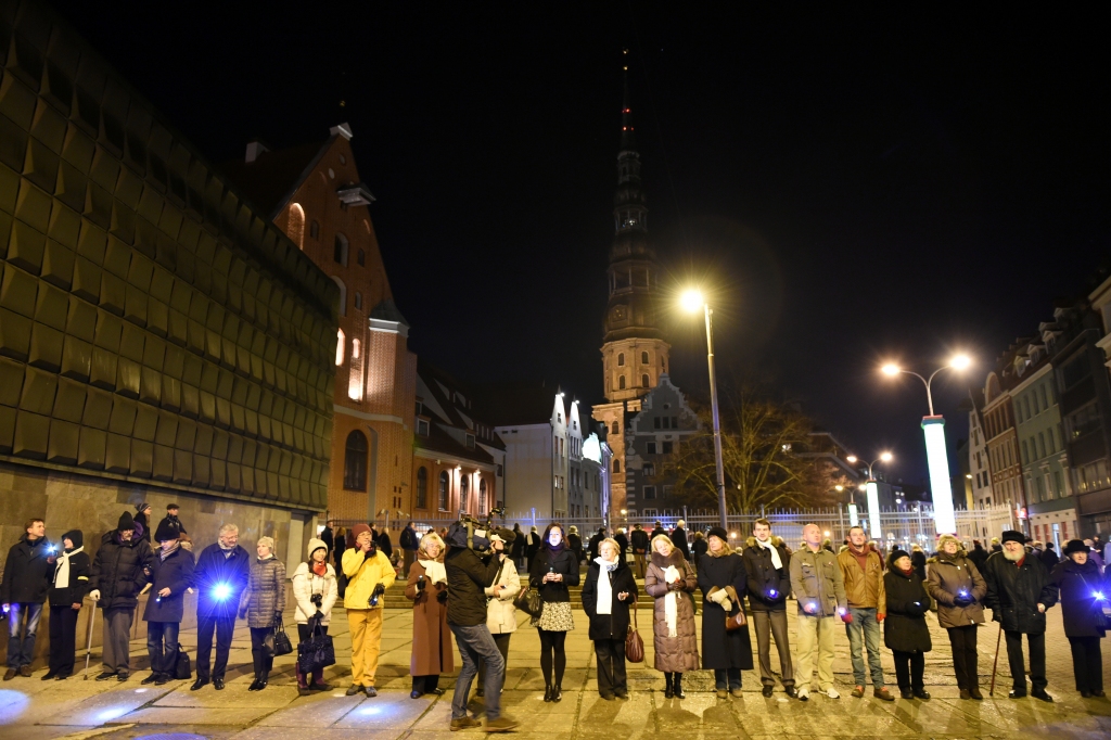 FOTO: Ap 100 cilvēku zibakcijā izgaismo Nākotnes nama kontūras